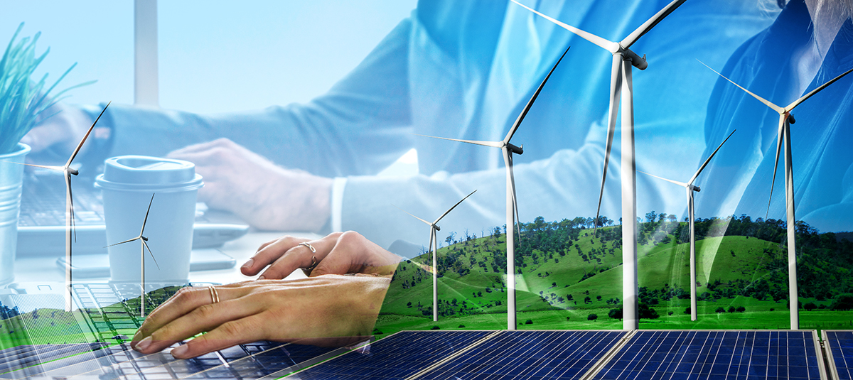 wind farm, green trees and overlay of worker at computer