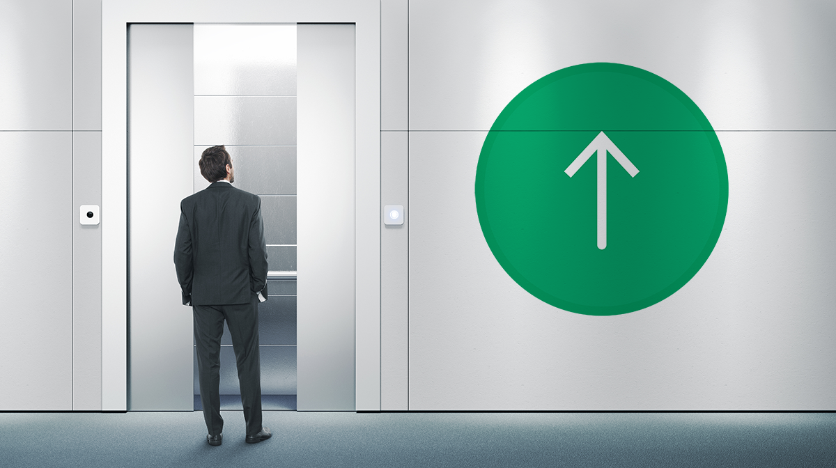 man standing in front of door by wall with large up green arrow