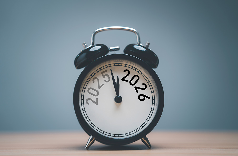 A black alarm clock with “2025” and “2026” on its face, symbolizing working capital management resolutions.