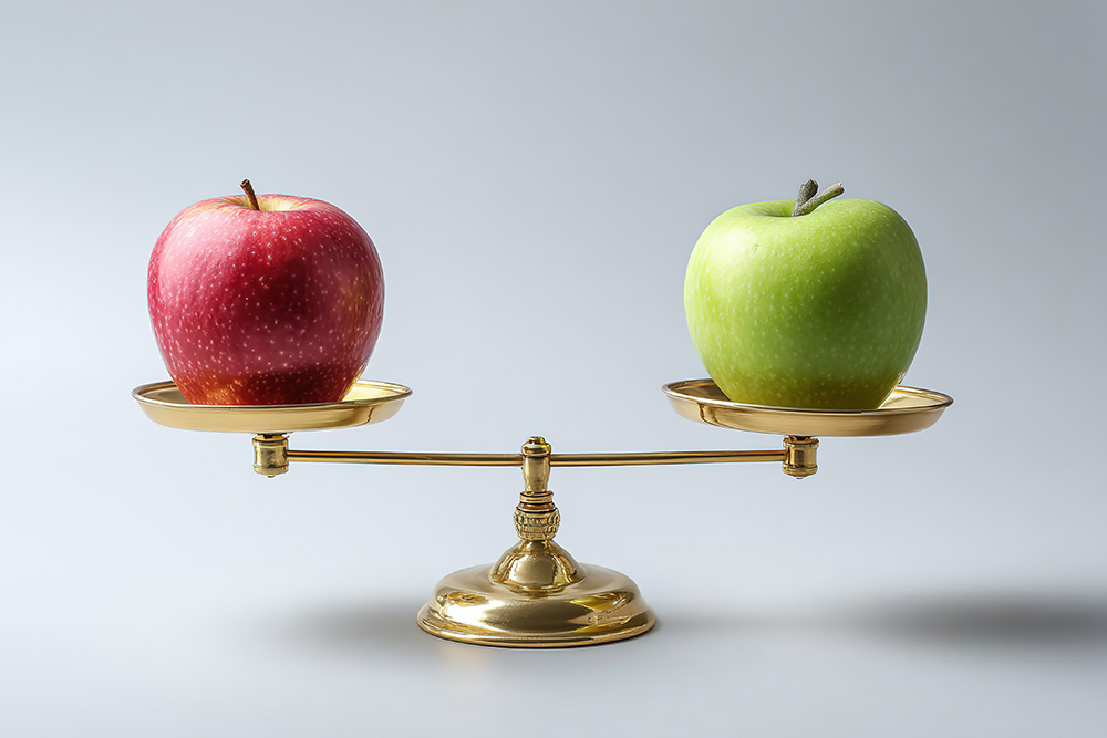 A red and a green apple balanced on a golden scale visually compare cost of capital on a light background.